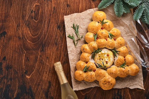 Pãezinhos Árvore de Natal com queijo camembert assado e alecrim em fundo rústico Receitas de férias Menu de Natal Pastelaria de Natal ou Natal Vista superior Espaço para Texto