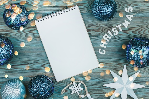 Página en blanco del cuaderno rodeado de adornos para árboles de Navidad