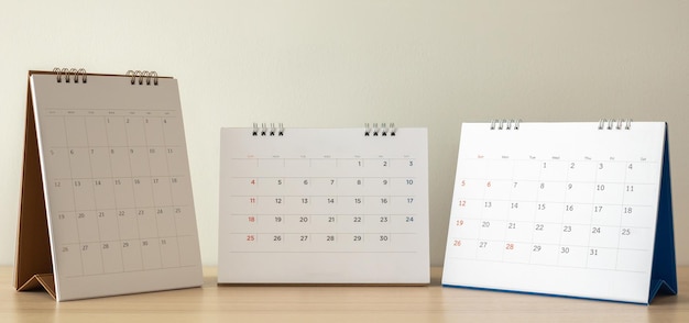 Página de calendario de cerca en la mesa de madera con fondo de pared blanca