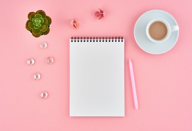 Página em branco do bloco de notas em branco e xícara de chocolate na mesa-de-rosa