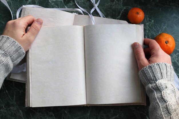 Las páginas en blanco abrieron el libro vintage en la encimera de mármol verde