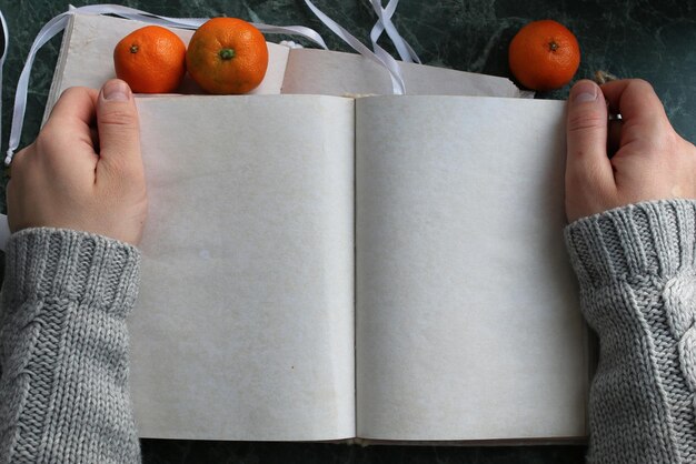 Las páginas en blanco abrieron el libro vintage en la encimera de mármol verde