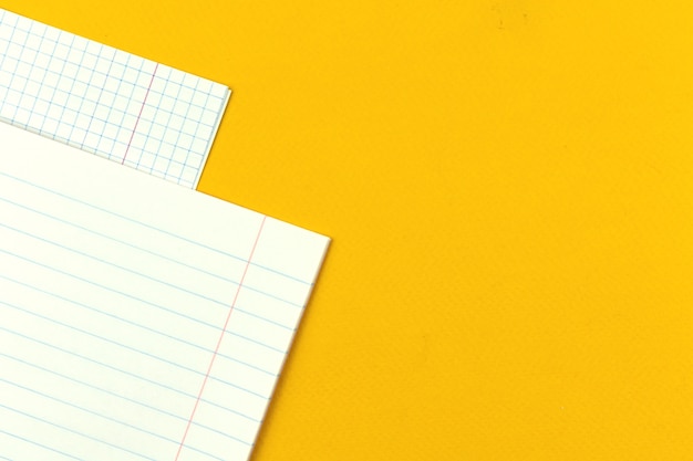 Páginas em branco de um close-up de caderno escolar em um fundo de área de trabalho de mesa amarela com foto do espaço de cópia