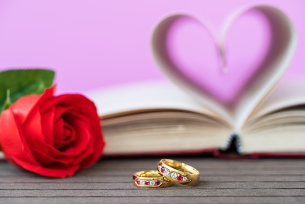 Foto páginas del libro curvadas en forma de corazón con rosa roja