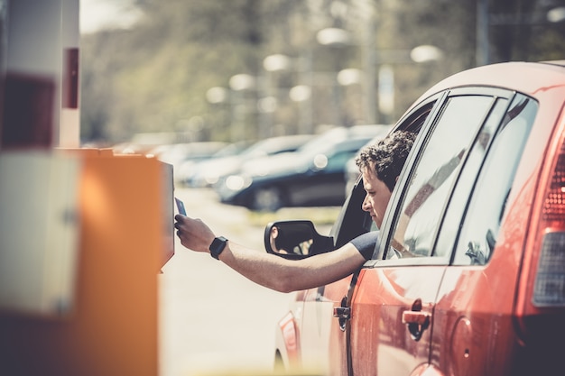 pago por estacionamiento con tarjeta de crédito. carro rojo