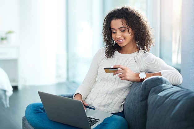 Pago en el hogar y mujer con tarjeta de crédito y portátil para inversión de préstamos estudiantiles con aplicación bancaria sofá de computadora y persona femenina con transacción de débito en línea para tasas de matrícula universitaria en la casa