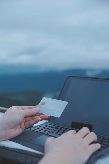 pago en línea mujer joven con tarjeta de crédito y escribiendo en la computadora portátil