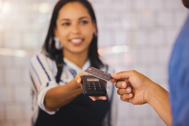 Pago con tarjeta de crédito y cliente con un lector electrónico en la mano de un cajero para procesar una compra de fintech o gastar dinero Consumidor que realiza una transacción bancaria o financiera en una cafetería