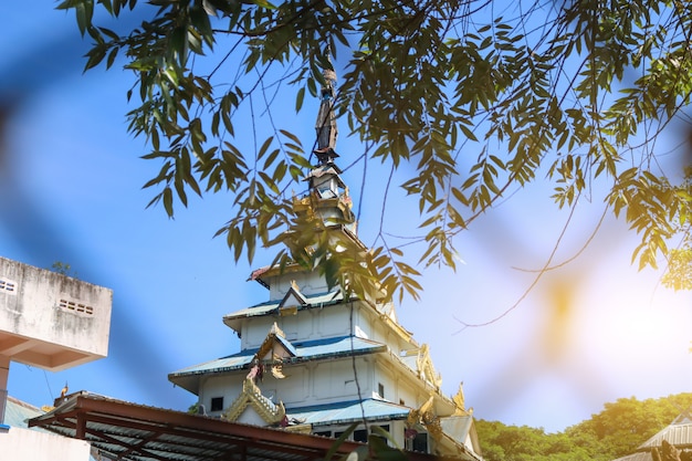 La pagoda de la arquitectura birmana con hojas verdes que cubren el frente durante el día.