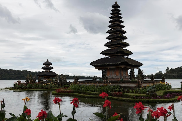 Foto una pagoda con un lago en el fondo y un cielo nublado