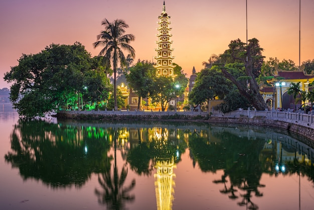 Pagode budista de Hanoi no lago ocidental, por do sol colorido, templo iluminado, reflexão da água. Viagem de Chua Tran Quoc em Ho Tay em Hanói, Vietnã.