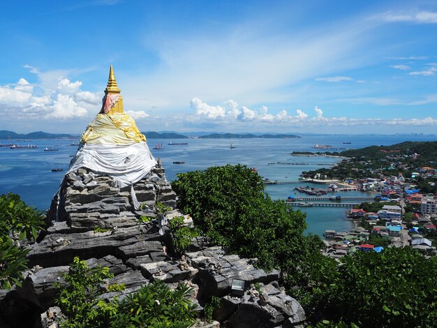 Pagode dourado em uma rocha na colina com vista para o mar, templo de Juthathit, ilha de Srichang