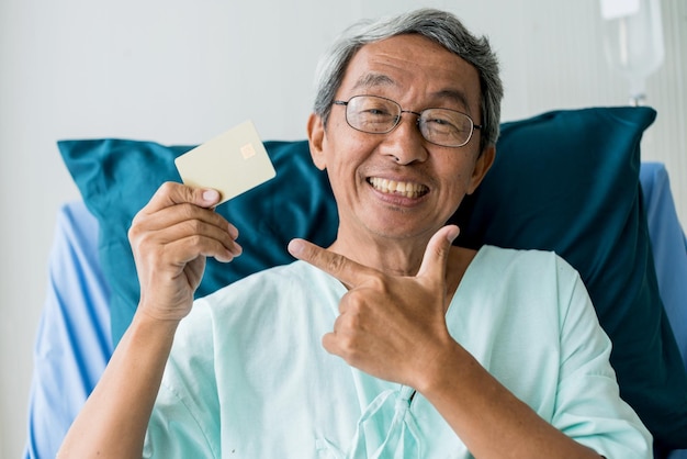 Pague o conceito de ideias de seguro hospitalar gratuito com felicidade paciente sênior mostra cartão de ouro grande sorriso sem preocupações