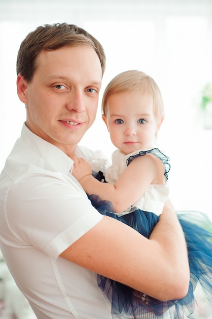 Pai abraçando e beijando sua filha pequena.