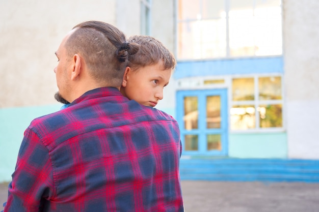 Pai abraçando seu filho antes de ele ir para a escola