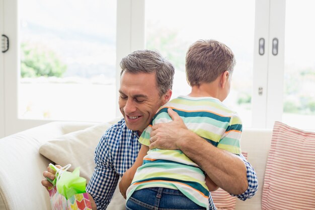 Pai abraçando seu filho na sala de estar