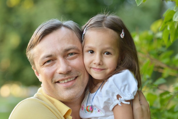 Foto pai abraçando sua filha na natureza