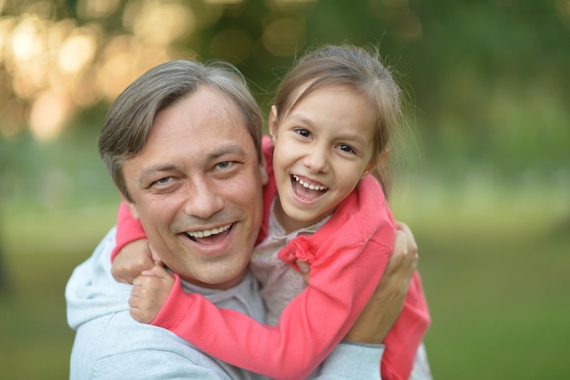 Pai abraçando sua filha na natureza