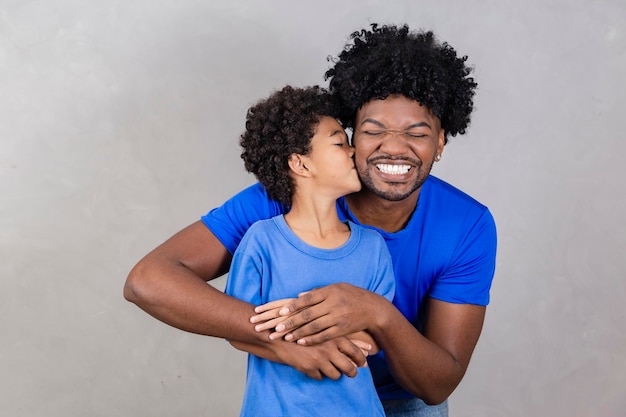 Pai afro e filho negro em fundo cinza sorrindo e feliz pai afro no dia dos pais dia dos pais em agosto