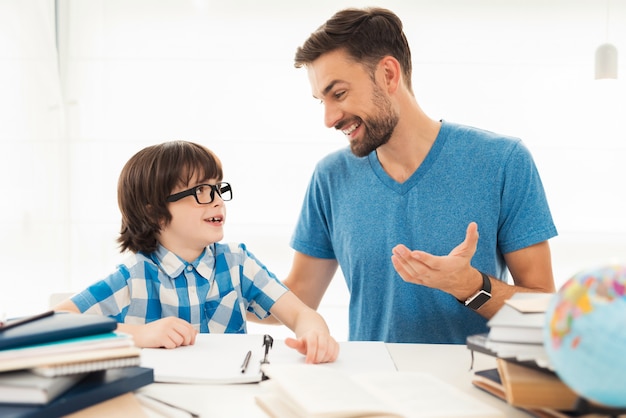 Pai ajuda seu filho a fazer lição de casa na escola.