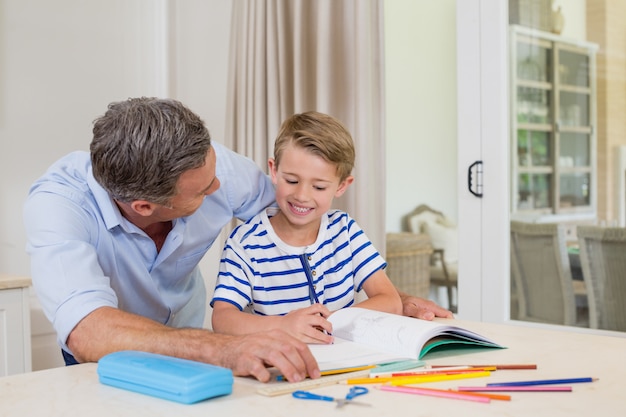 Foto pai ajudando filho fazendo lição de casa