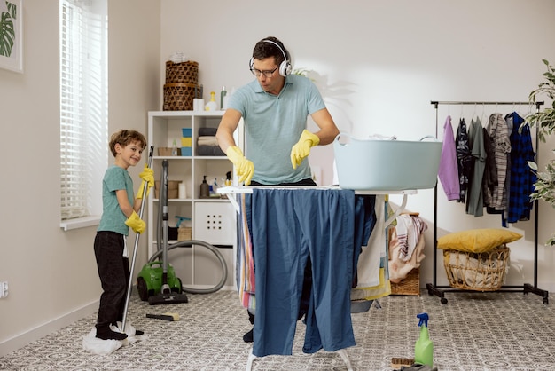 Pai alegre passa tempo com filho no banheiro da lavanderia homens brincam enquanto limpam