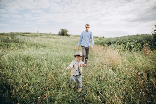 Pai andando no campo com seu filho pequeno