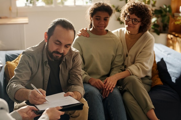 Pai assinando contrato de custódia com assistente social