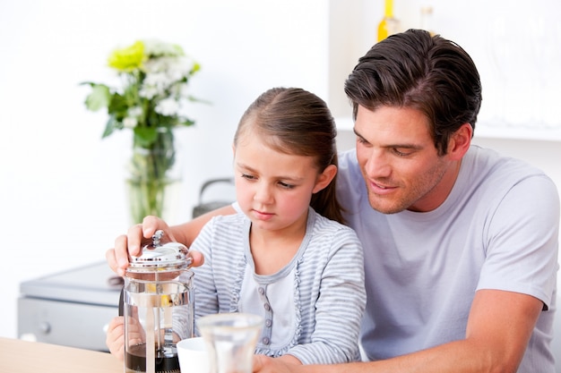 Foto pai atencioso e sua filha tomando café da manhã juntos