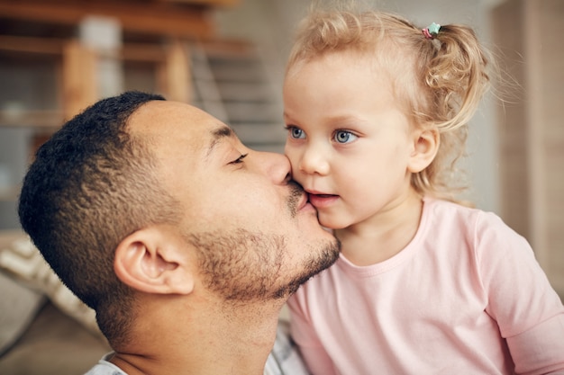 Pai beijando filha pequena