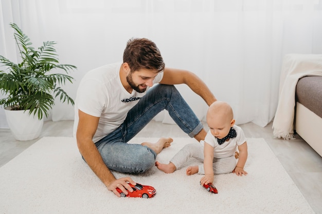 Foto pai brincando com bebê em casa