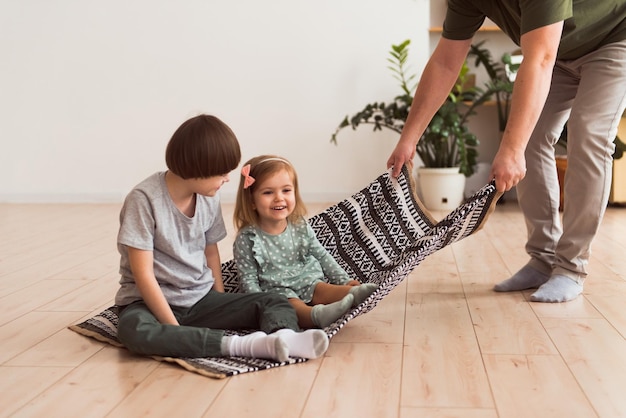 pai brincando com filhos filho com síndrome de Down e filha