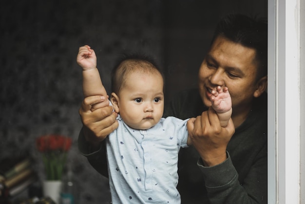 Pai brincando com menino fofo dentro de casa