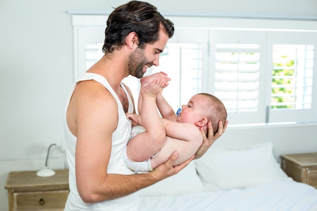 Pai brincando com o filho na cama