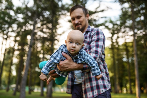 Pai brincando com seu bebê no parque de verão