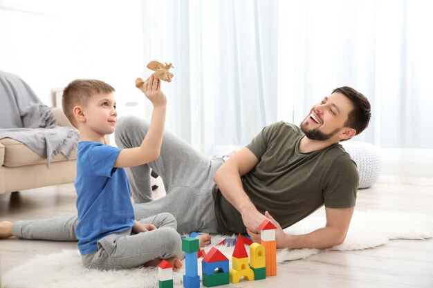 Foto pai brincando com seu filho em casa