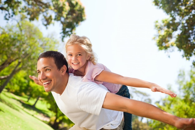 Pai brincando com sua filha no parque