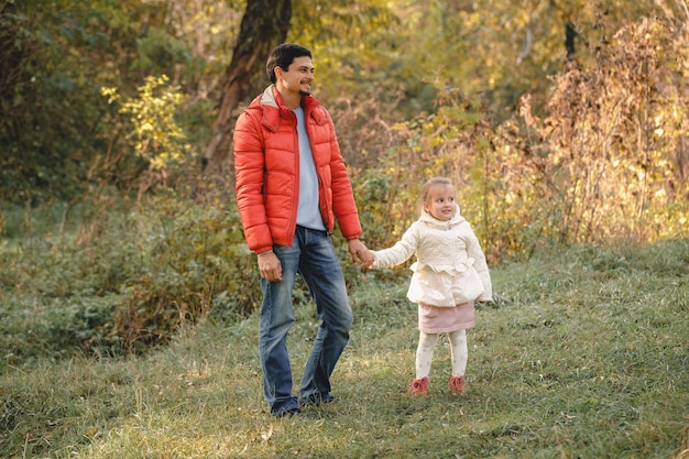 Pai caminha com filha menina e sorri alegremente