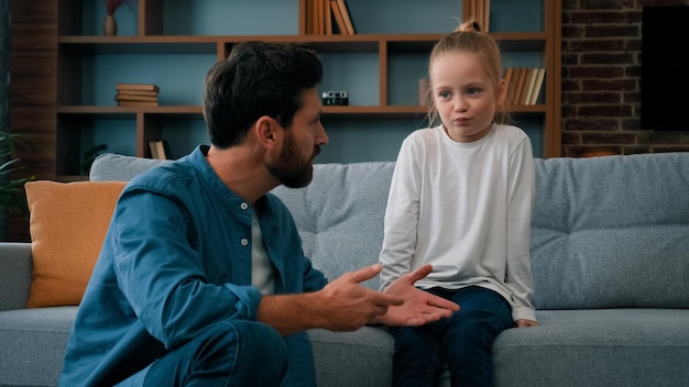 Pai carinhoso homem caucasiano pai falando com criança ofendida menina ajudando filha pequena família