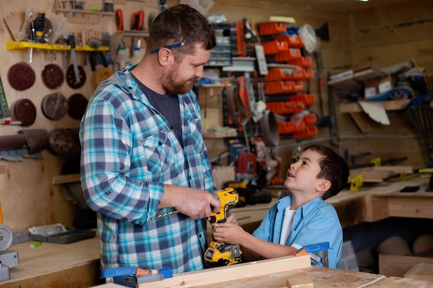 Pai carpinteiro e filho menino trabalham na oficina Pai mestre ensina seu filho carpintaria Continuidade