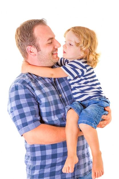 Foto pai carregando filho enquanto está de pé contra um fundo branco