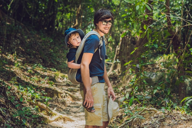 Pai carregando seu filho nas costas na natureza