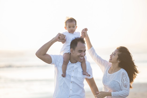 Pai com bebê fofo na praia se divertindo juntos