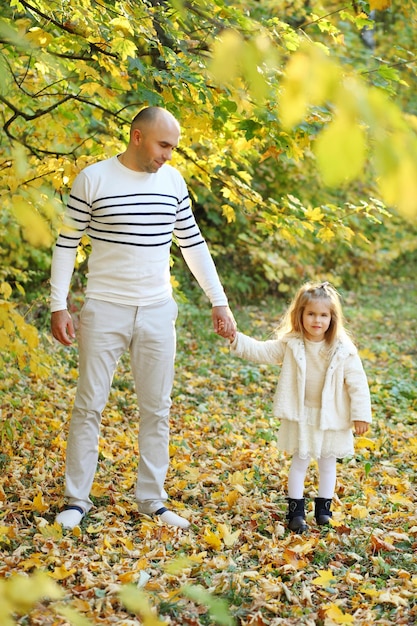 Pai com filha está andando no parque outono