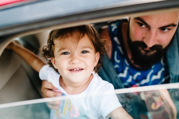 Pai com filha sentada em um carro nas ruas da cidade de Tbilisi, na capital da Geórgia, em dia ensolarado de primavera Pai e filha viajam em excursão na cidade velha