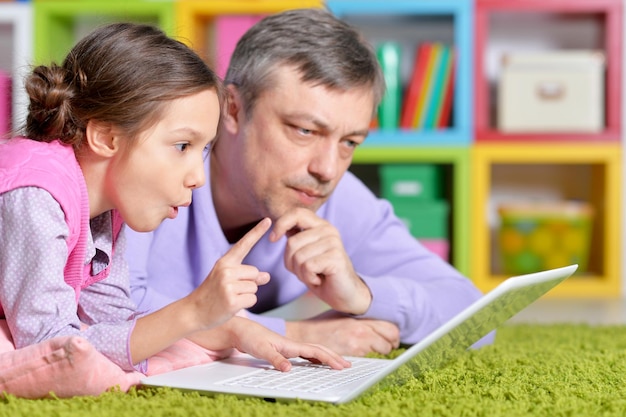 Pai com filha usando laptop