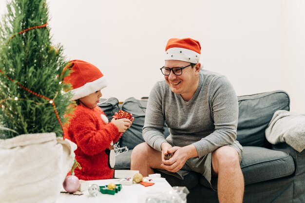 Foto pai com filho em casa comemorando o natal.