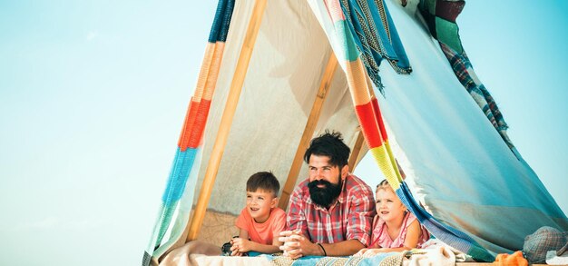 Pai com filhos brincando juntos na tenda verão família ao ar livre brincando juntos pai feliz com criança