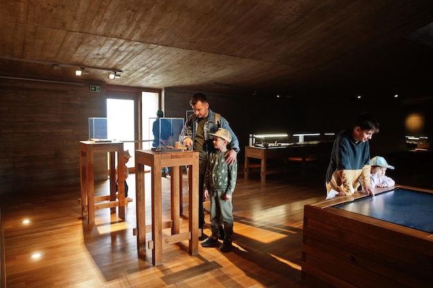 Pai com filhos explorando exposições em salas de museus