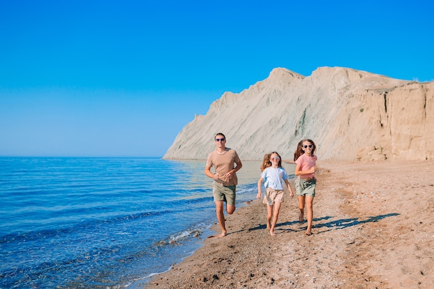 Pai com filhos na praia, aproveitando o verão. Férias com a família